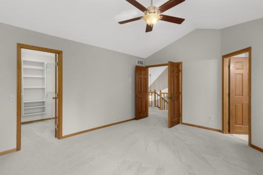 Primary bedroom suite with ensuite bathroom, vaulted ceiling, ceiling fan & walk-in closet