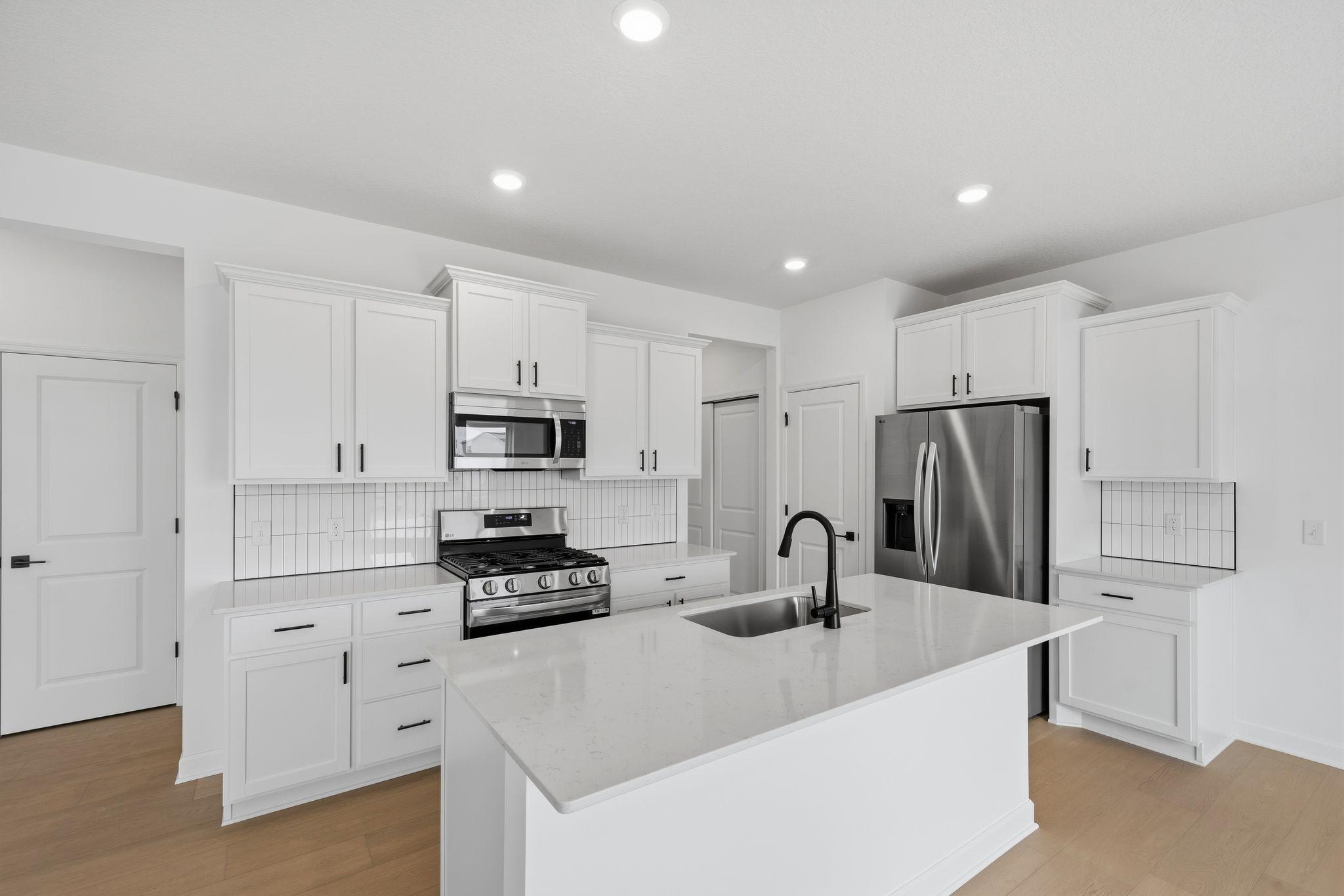 (All the following photos are of a similar home, actual finishes may vary.) This stylish kitchen showcases a large center island, brand-new stainless-steel appliances and designer cabinetry with plenty of storage.