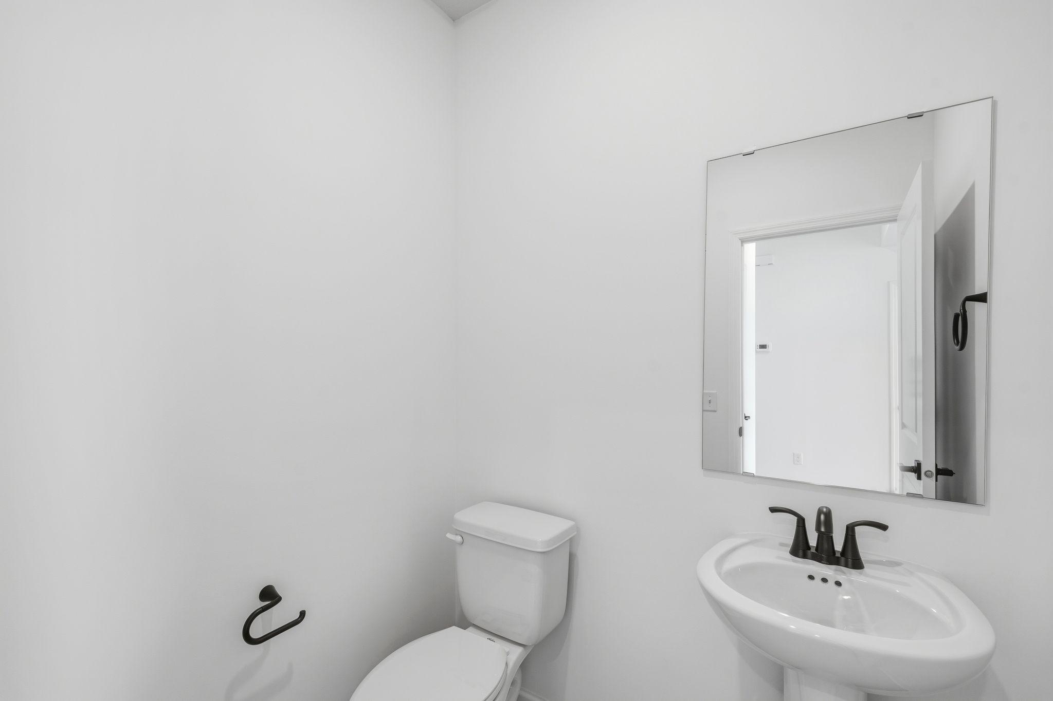 (Photo of a similar home, actual finishes may vary) In a discreet location on the first floor is a convenient powder room to accommodate the needs of the whole household and visiting guests.