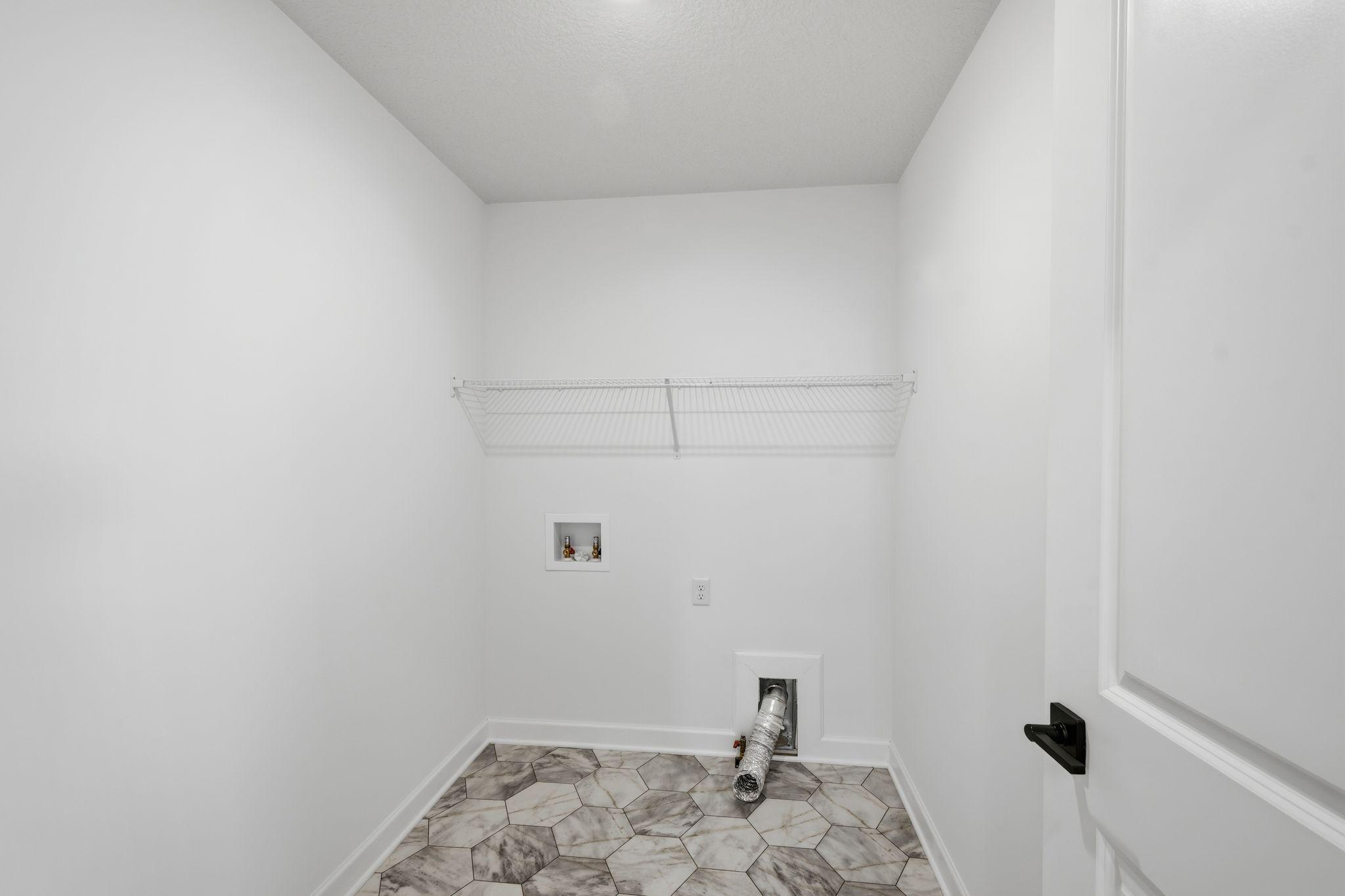 (Photo of a similar home, actual finishes may vary) The laundry room features ventilated shelving for all your storage needs