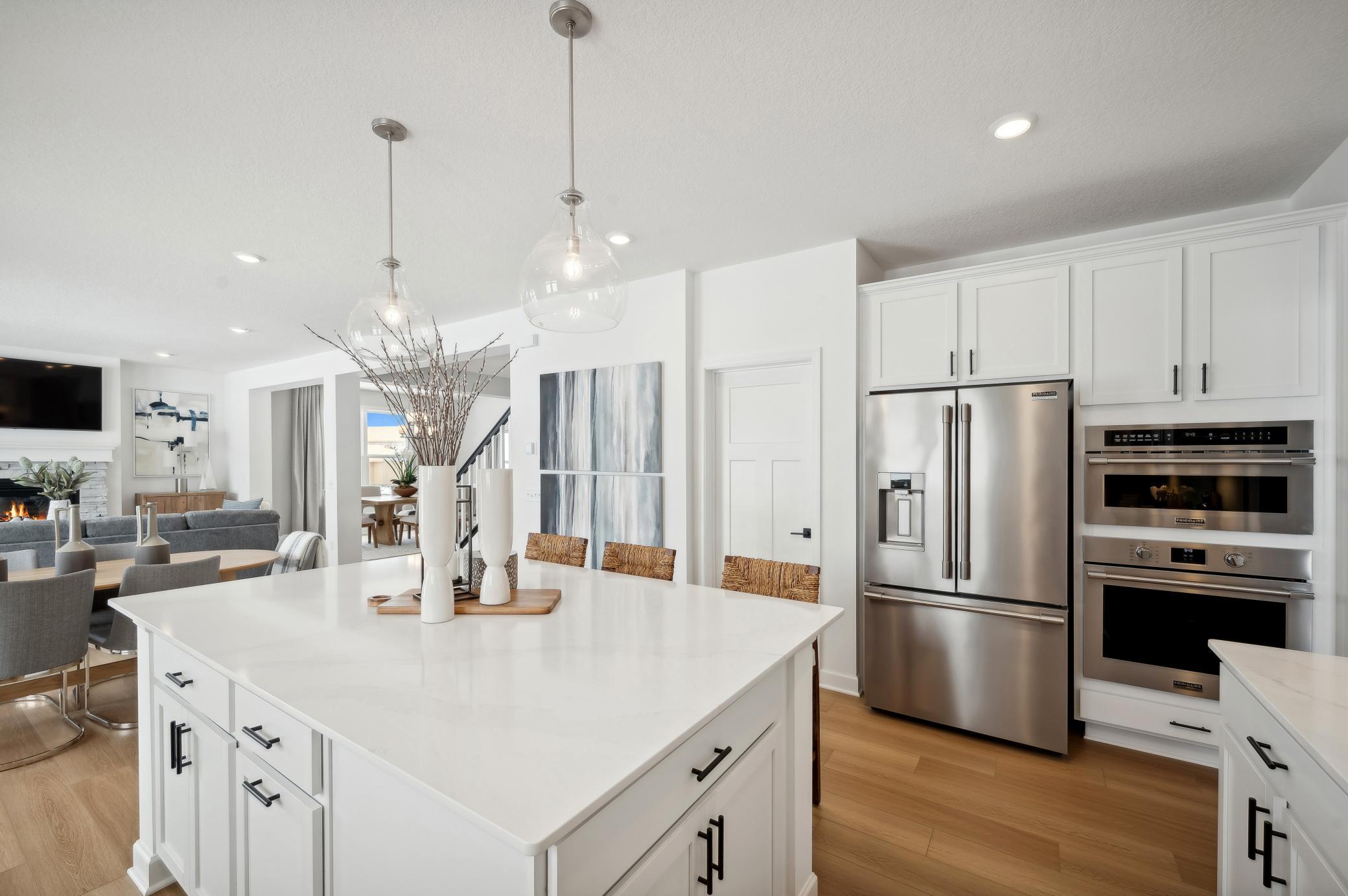 (Photo of model home, finishes will vary) Welcome to the Itasca! This spacious kitchen includes a large center island, quartz countertops, recessed lighting, LVP wood floors, stainless appliances and more.