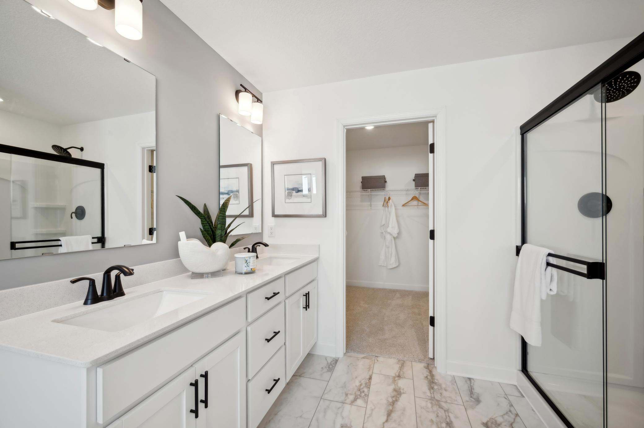 (Photo of model home, finishes will vary) An extension of the owner's suite, this private and spacious bath contains a double-vanity, a soaking tub, a separate shower and a walk-in closet.