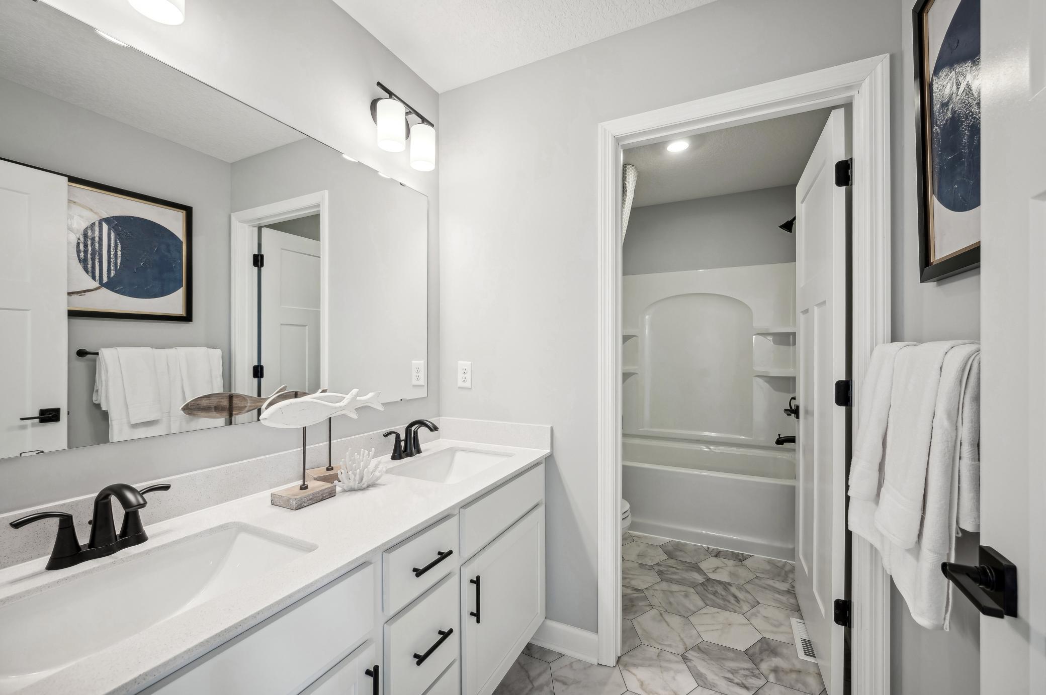 (Photo of model home, finishes will vary) Featuring a double-vanity, this secondary bath is sure to keep everyone moving during those busy mornings!