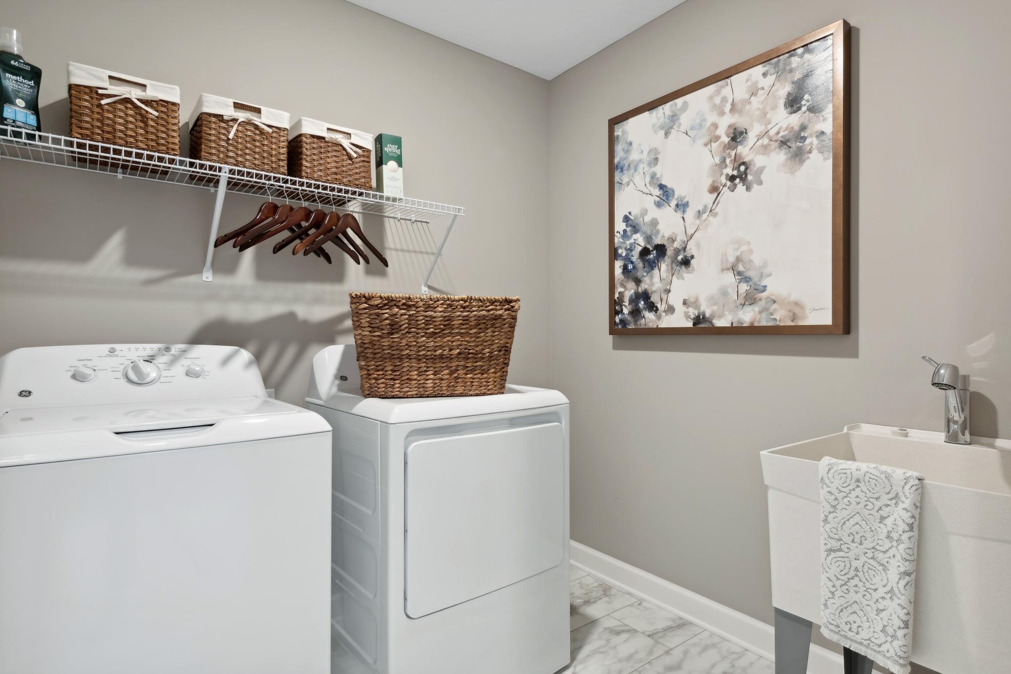 (Photo of model home, finishes will vary) Laundry room with ventilated shelving for your storage needs