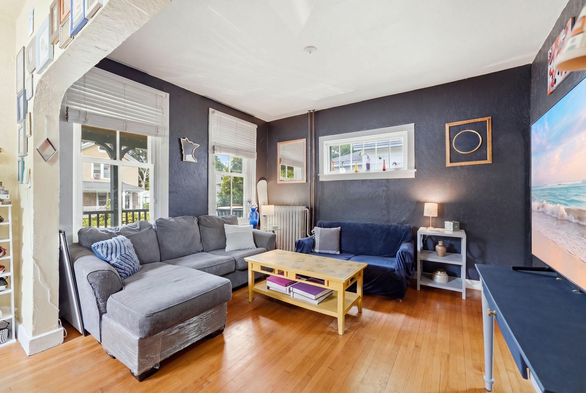 Sunlit living room accentuated by gleaming hardwood floors.