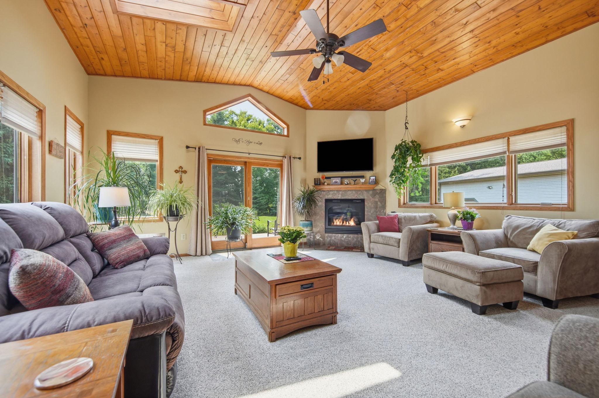 Main floor living room is a stunner with vaulted ceilings, gas fireplace, and patio doors leading to the backyard deck.