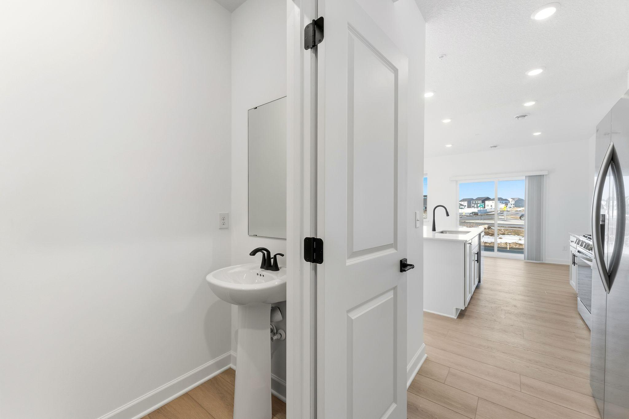 (Photo of a similar home, actual finishes may vary) Situated directly off the kitchen, this powder room optimizes the first-floor main living area for residents and guests alike.