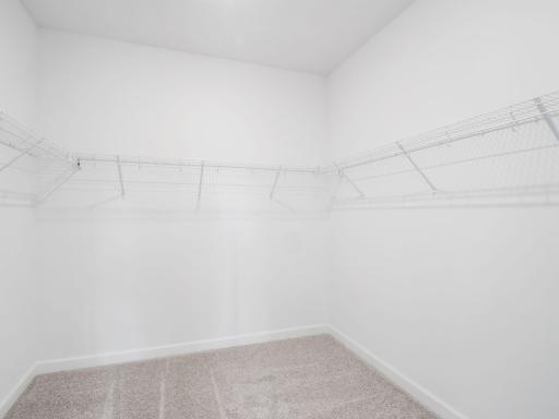 Built-in wire shelving optimizes this oversized walk-in closet for organizing wardrobes, shoe collections, accessories and linens