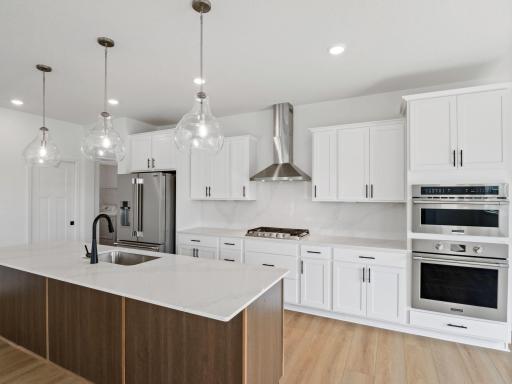 The modern kitchen comes equipped with popular features like smudge-proof appliances and designer-selected cabinetry, along with a spacious center island for bar-style meals and easy entertaining.