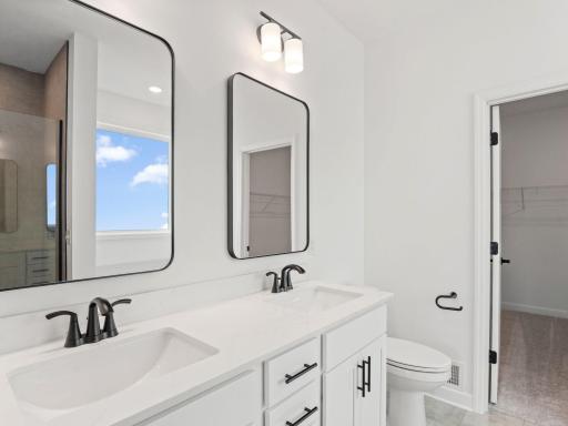 Individual vanity mirrors and Moen® chrome-finish faucets brighten twin undermount sinks