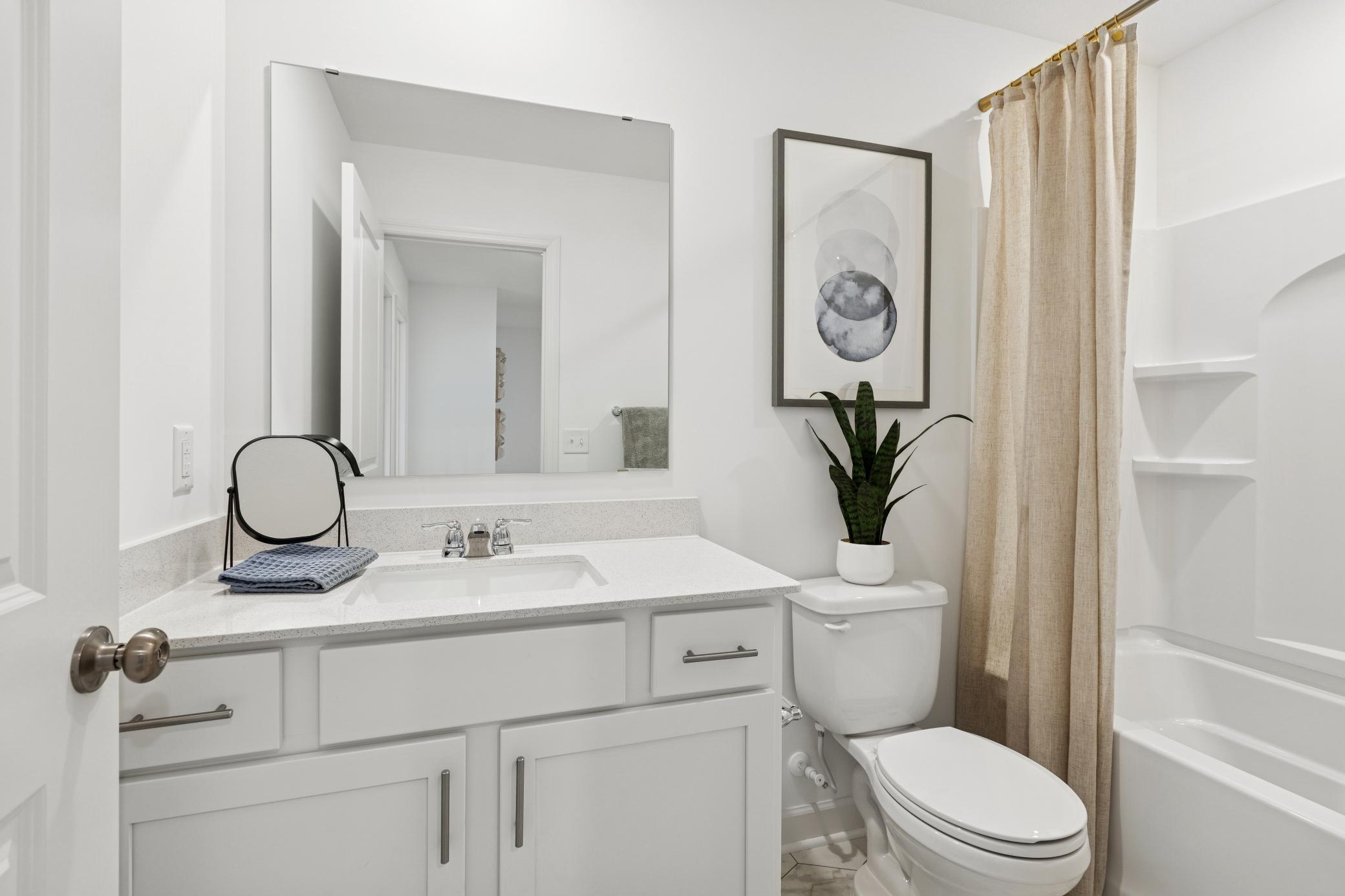 (Photo is of a model home, finishes will vary) A full bathroom on the second floor comes well-equipped with a stylish vanity and a combination shower and tub.