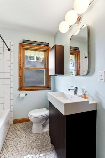 Remodeled full bath with tile surround and floor