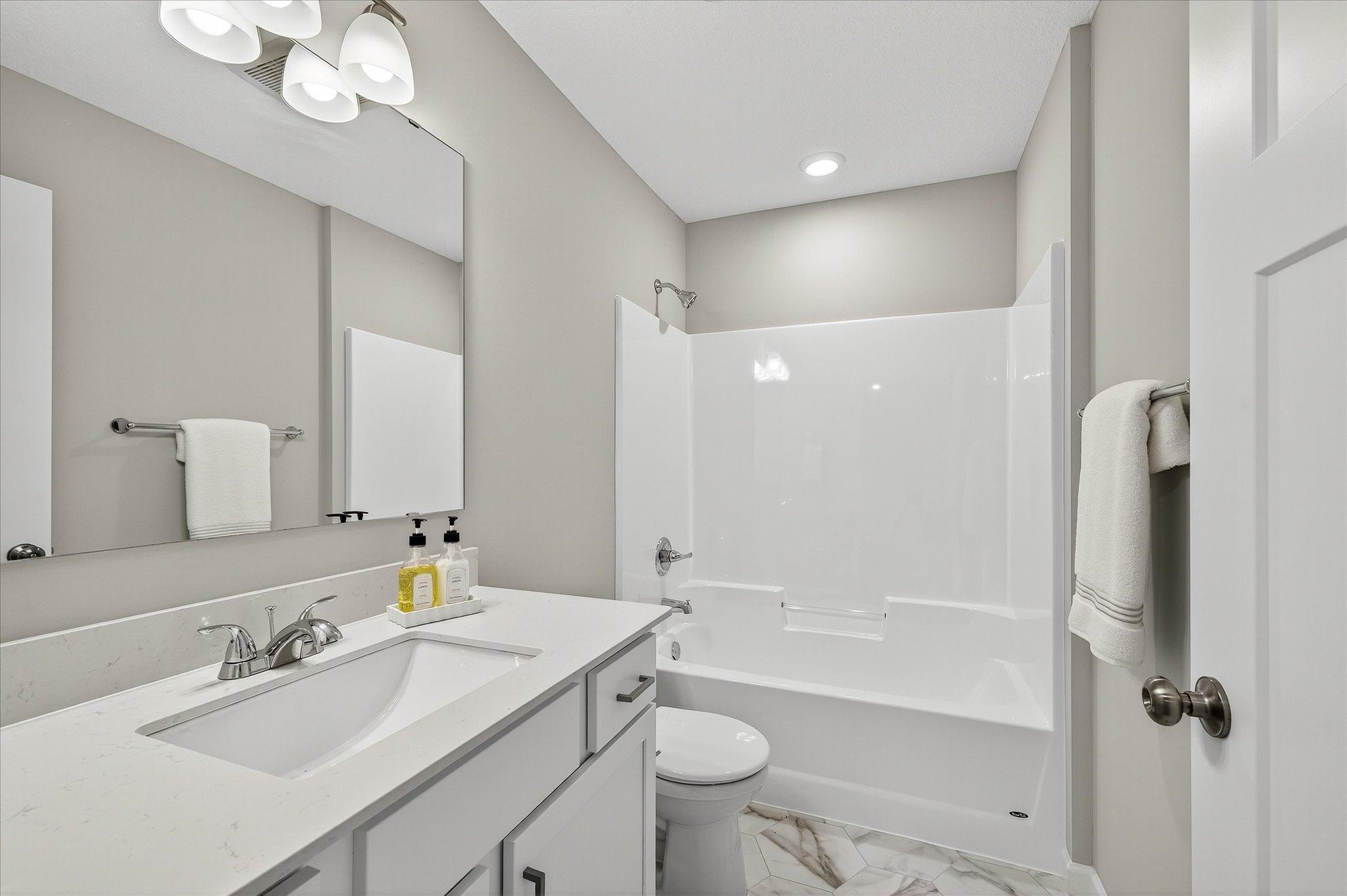 A conveniently located full bathroom keeps the home's main level functional for family and overnight guests alike. *photos of a previously staged home, not all options & finishes may be exact.*