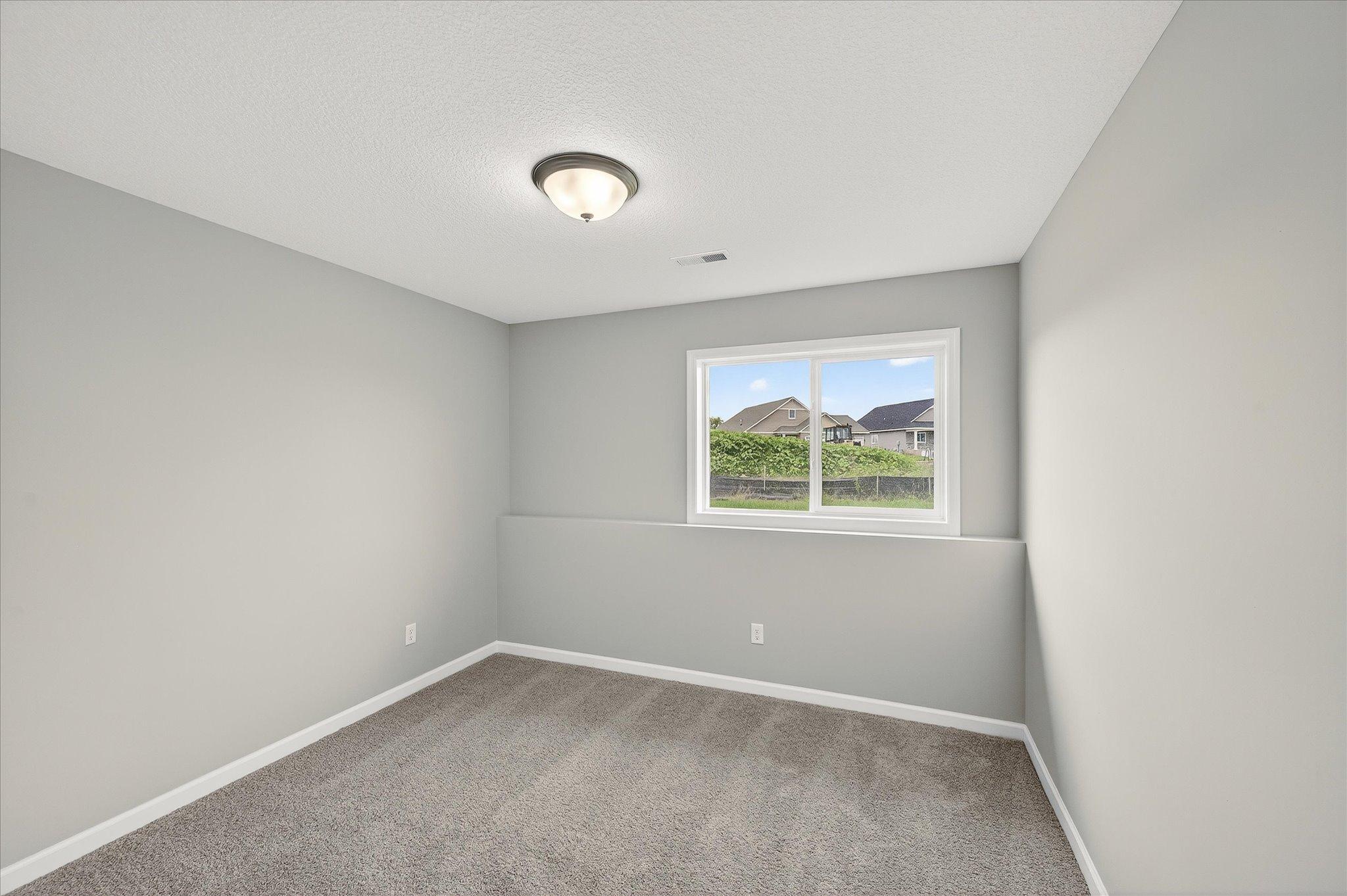 A finished lower-level bedroom creates comfortable separation for overnight visitors, older kids, or extended family. *photos of a previously staged home, not all options & finishes may be exact.*