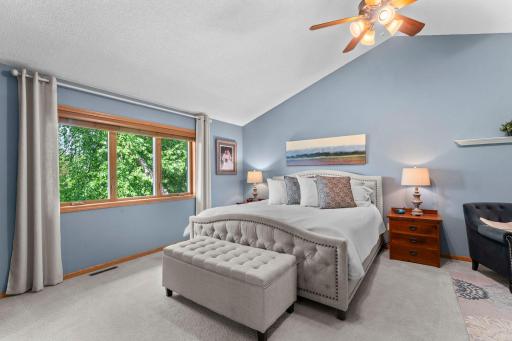Primary bedroom with large window overlooking the private backyard