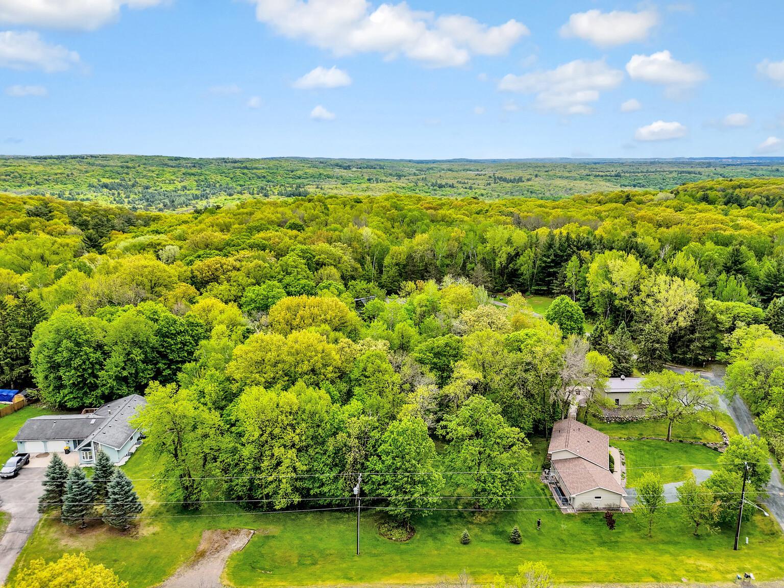 Wooded lot between the 2 houses - There is a driveway entrance cut into the property
