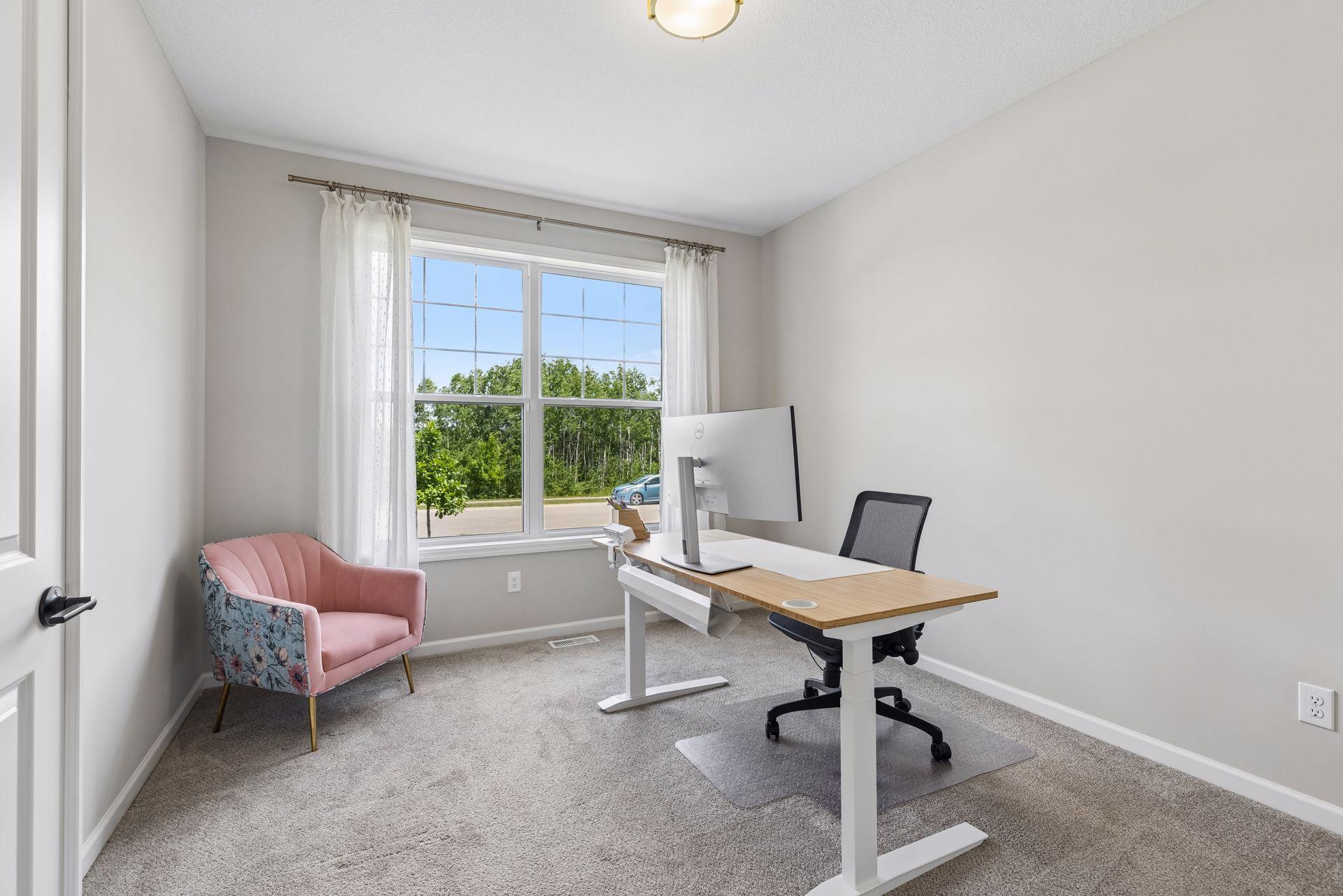 Just beyond the welcoming foyer, a sunlit office framed by a large picture window provides an ideal space for work or study