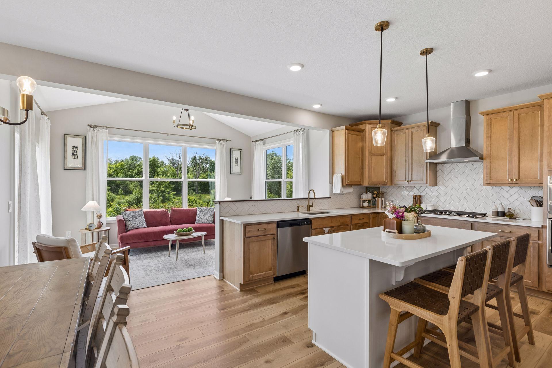 Beyond the kitchen, a three-season porch wrapped in windows offers a front-row seat to the changing seasons and surrounding nature.