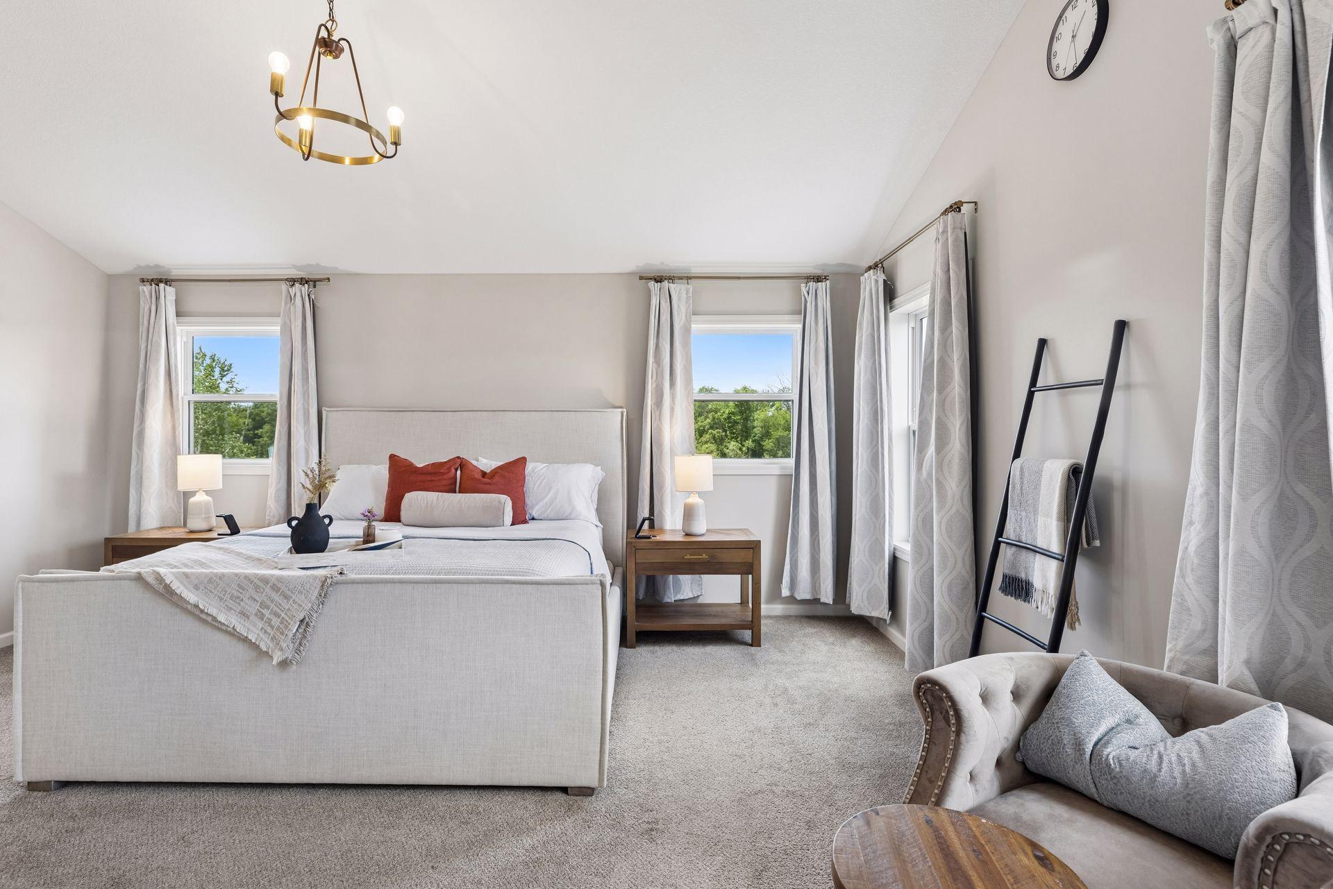 The spacious bedroom includes room for a sitting area, while two separate walk-in closets—one with space for a vanity—provide exceptional storage.