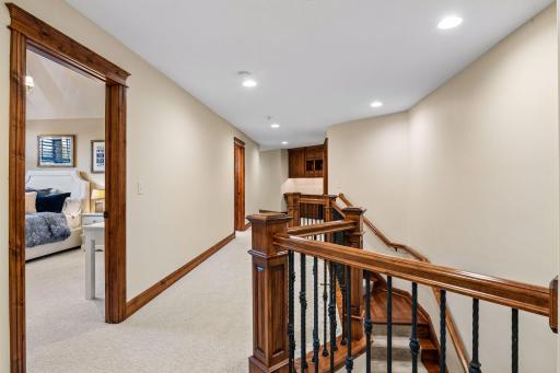 The upper-level hallway features a custom built-in desk area, creating a comfortable spot for work or study.