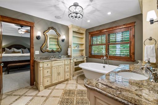 The large primary bathroom features two separate vanities and a relaxing soaking tub.