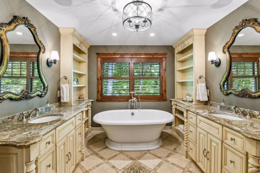 The luxurious primary bathroom offers plenty of storage throughout.