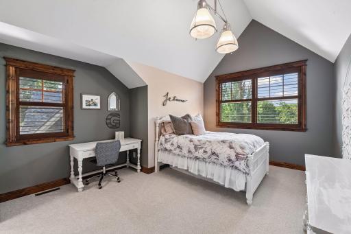 The third upper-level bedroom features a unique vaulted ceiling, adding architectural interest and spacious appeal.
