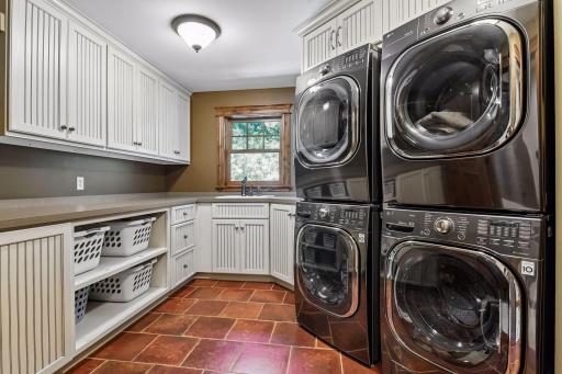 This spacious upper-level laundry room offers two washers, two dryers, plenty of storage, and great counter space for folding and organization.