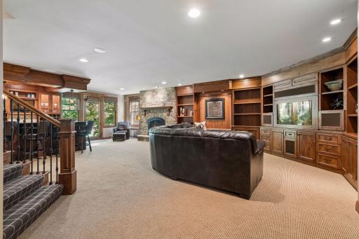 This inviting lower-level family room includes custom built-ins with a media center, creating a cozy and organized space for relaxing or entertaining.