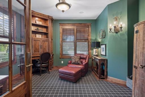 The main-floor office, accessed from the living room, features custom built-ins for a refined and functional workspace.