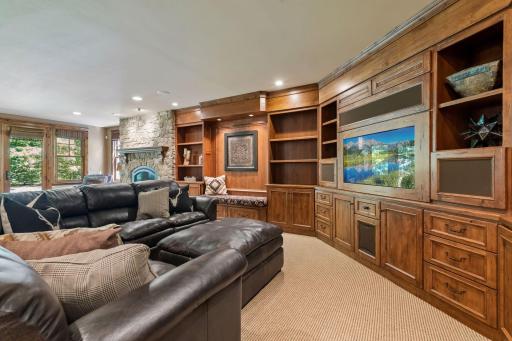 The family room features custom built-ins with a dedicated media center and a beautiful fireplace, creating a warm and refined gathering space.