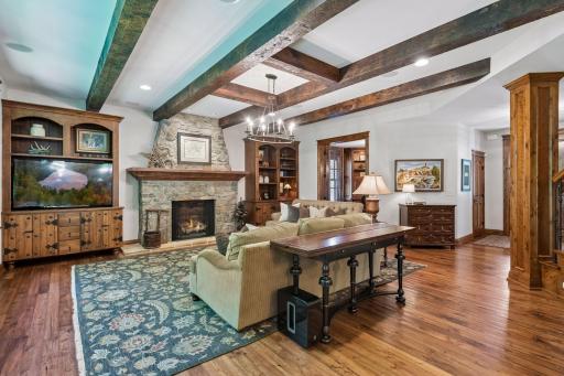 The living room features a striking beamed ceiling and beautiful wood floors, creating a rich, welcoming atmosphere.