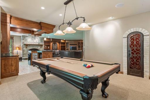 Right off the game room sits a spacious wine room, perfect for storing and showcasing your collection in an inviting, accessible spot.