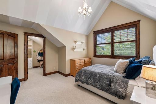 The fourth upper-level bedroom features its own walk-in closet and an attached ¾ bathroom, creating a private and comfortable suite.