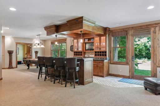 This spacious lower-level bar includes a generous counter area and a convenient sink, ideal for hosting gatherings.