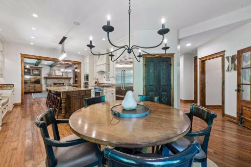 The informal dining area moves effortlessly into the kitchen, with rich wood floors adding warmth and continuity throughout the space.