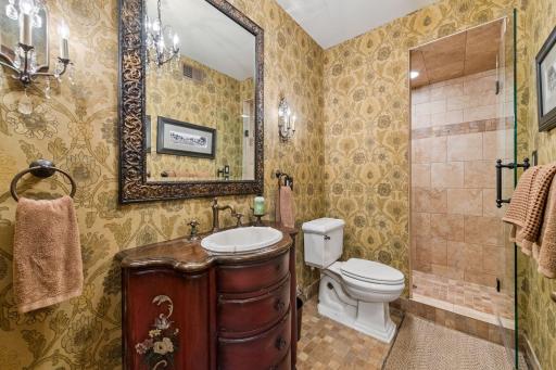 This lower-level ¾ bathroom includes a beautifully crafted custom vanity, adding warmth and style to the space.