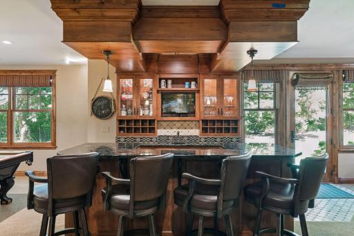 The beautifully crafted bar is positioned right beside the game room, making it easy to gather, serve drinks, and enjoy time together.