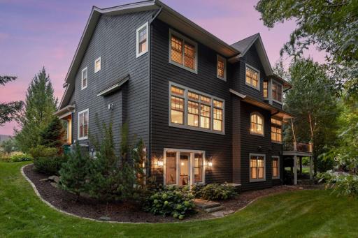 The back of the home features expansive windows overlooking the private backyard.