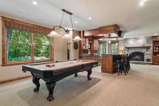 The game room area is perfectly suited for a pool table and opens seamlessly to both the bar and family room for effortless entertaining.