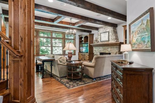 From the foyer, you step into a cozy living room anchored by a stunning stone gas fireplace and beautiful custom built-ins.