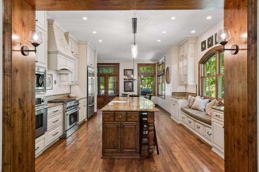 A generous kitchen offers a large center island and a cozy window seat perfect for morning coffee or reading.