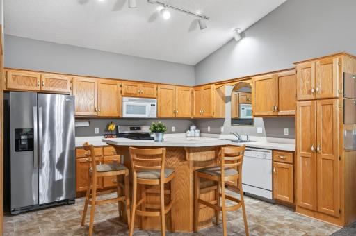 This kitchen maximizes functionality with generous cabinetry, vast counter space, and a distinct two-tier island for breakfast bar dining.
