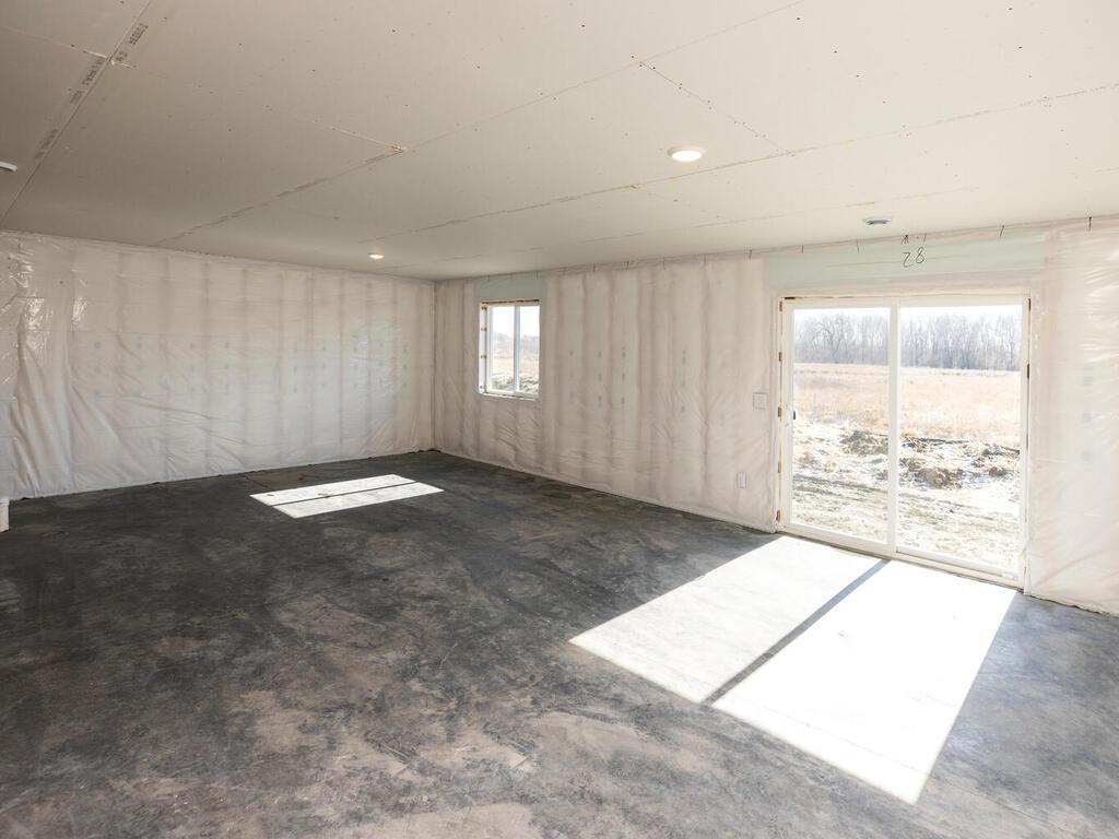 Unfinished Lower Level. Photo taken of another home with similar plan and finishes. Photos and renderings may not depict actual plan, materials, & finishes may vary. All measurements are approximate.