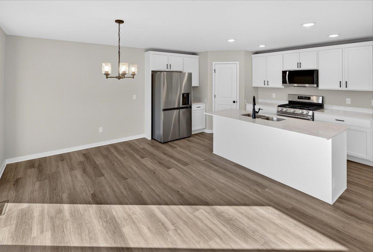 Dining Room & Kitchen. Photo taken of another home with similar plan and finishes.