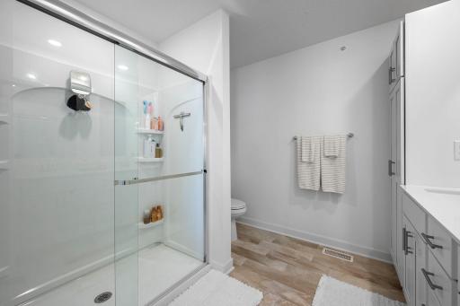 A large glass-enclosed walk-in shower completes the primary bath