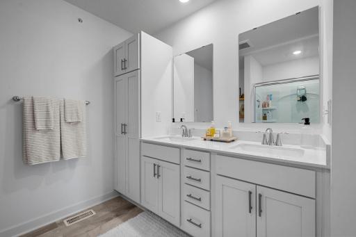Clean, modern finishes continue into the primary bath with dual sinks, generous storage, and a bright, fresh feel