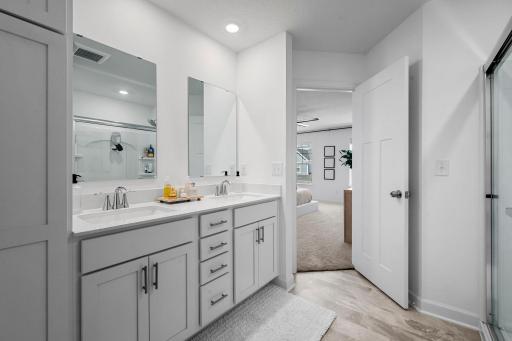 The private primary bath features a spacious double vanity with plenty of cabinetry and counter space to make busy mornings a little easier