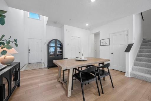 Warm flooring, crisp white finishes, and plenty of natural light create a bright and welcoming dining space