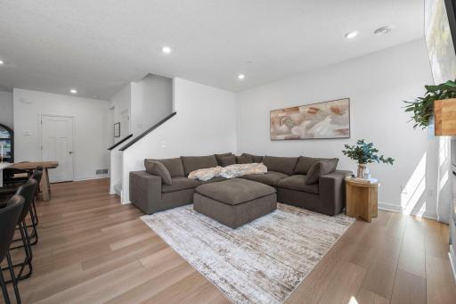 Comfortable and inviting, the living room offers plenty of space to settle in while warm flooring and recessed lighting keep the look fresh and modern